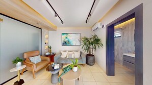 A modern living room with a sofa, a coffee table, a side table, and a potted plant. - Exclusivo zona A (Santiago de los Caballeros)