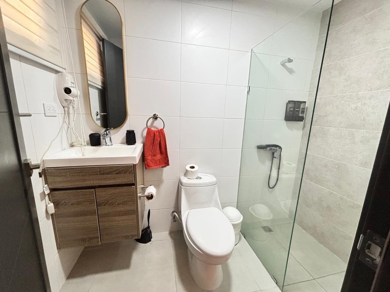 Ein modernes Badezimmer mit Toilette, Bidet und einer Duschkabine aus Glas.