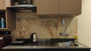 A modern kitchen with a built-in stove, a sink, and a marble backsplash.