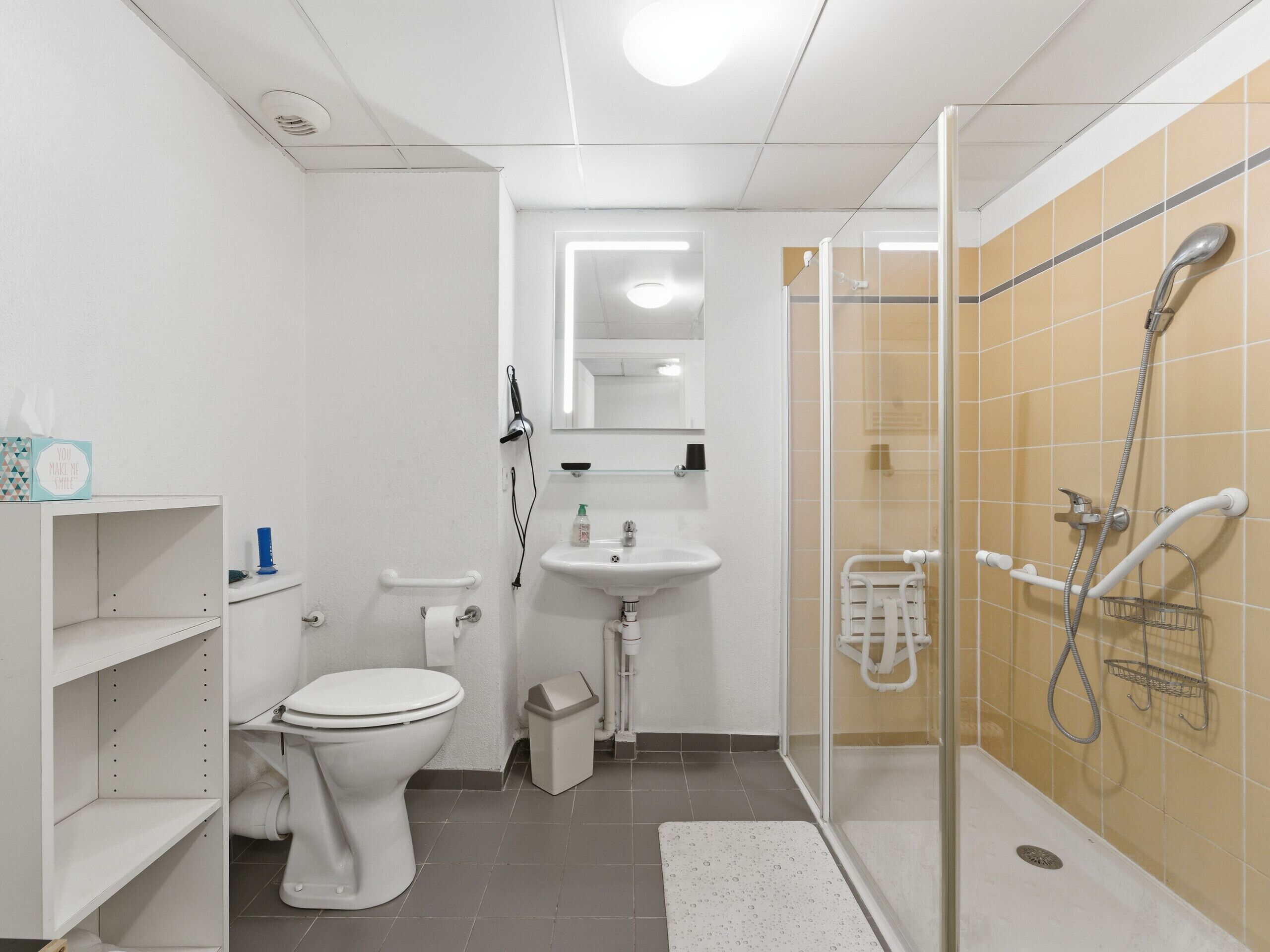 Een moderne badkamer met toilet, wastafel en douche.