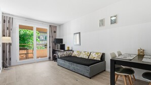 Ein modernes Zimmer mit einer Couch, einem Esstisch und einem Fernseher.