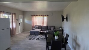 A compact living space with a kitchenette, a sofa set, a dining table, and a small potted plant. - Modern 1BR Mountain View Retreat w/ AC & Full Kitchen (Saint Peter)
