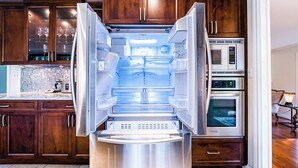 A stainless steel refrigerator with a freezer compartment, built-in ice maker, and a microwave above it. - Comfortable Room in a Shared Home (Vancouver)