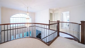 A spacious interior with a curved staircase, a large window, and a chandelier. - Comfortable Room in a Shared Home (Vancouver)