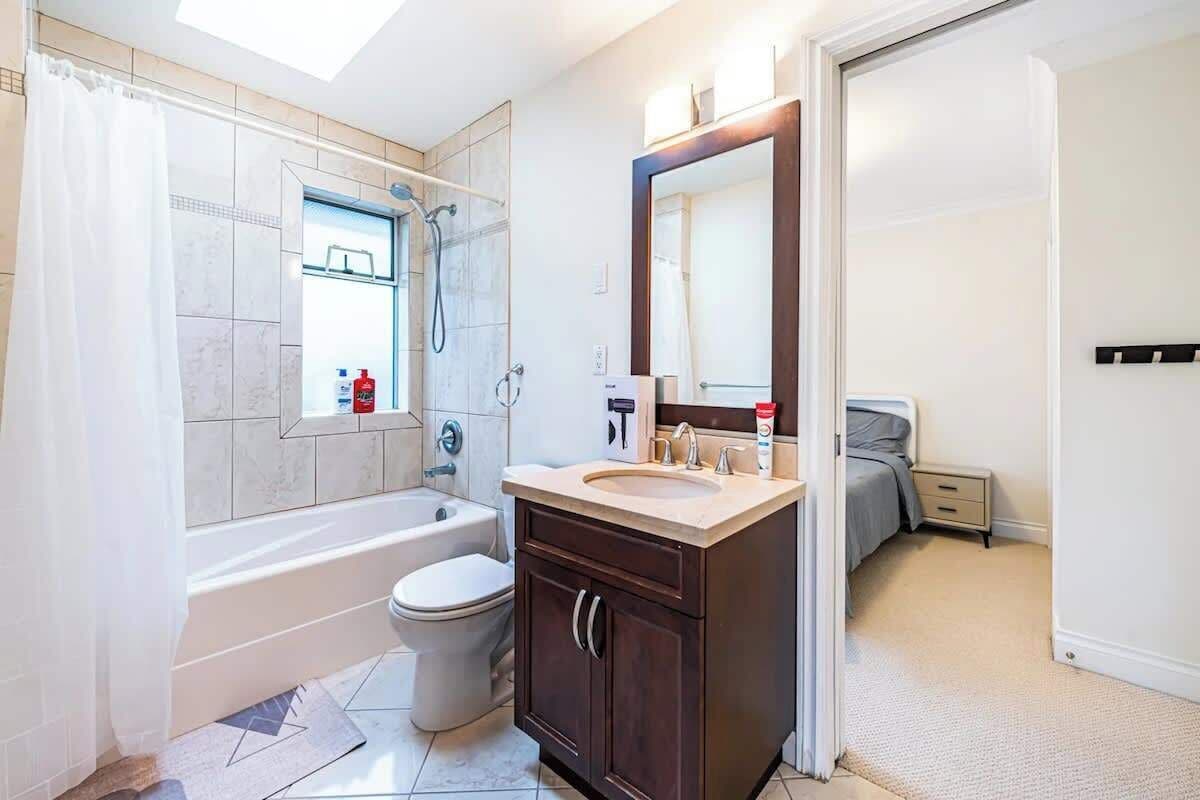A bathroom with a bathtub, toilet, sink, and mirror.