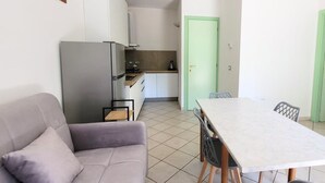 A compact living space with a kitchenette, a dining table, and a sofa. - RP03 - Cesenatico, new apartment near the sea (Cesenatico)