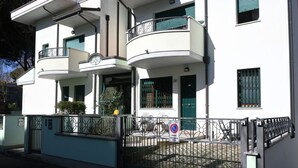A multi-story building with balconies, a gated entrance, and a no parking sign. - RP03 - Cesenatico, new apartment near the sea (Cesenatico)
