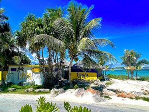 A beachfront property with a yellow building labeled 'Tipy's' and a palm tree. - Cute as a Button, AC, Starlink, Wi-Fi, Hot Tub, Near Beaches, Bars & Restaurants (North Palmetto Point)
