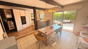 Eine moderne Küche mit Essbereich, großen Fenstern und Blick ins Freie.