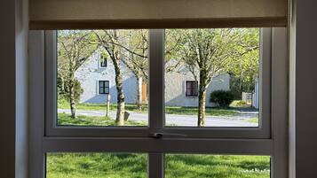 A window with a view of a house and trees.