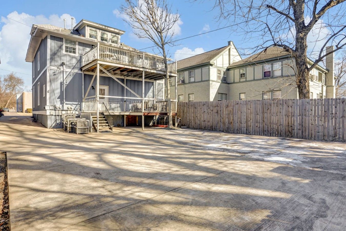 A two-story building with a balcony and a wooden fence.