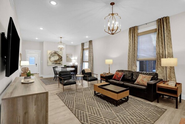 A modern living room with a sofa, coffee table, and dining area.