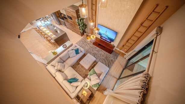 A modern interior with a dining area, sofa set, TV, and a staircase. - Go!#40 - MAGIC VILLAGE VIEWS (Kissimmee)