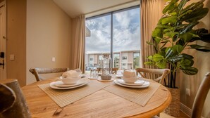 A round dining table with placemats, white plates, and cups, set for two. - Go!#40 - MAGIC VILLAGE VIEWS (Kissimmee)