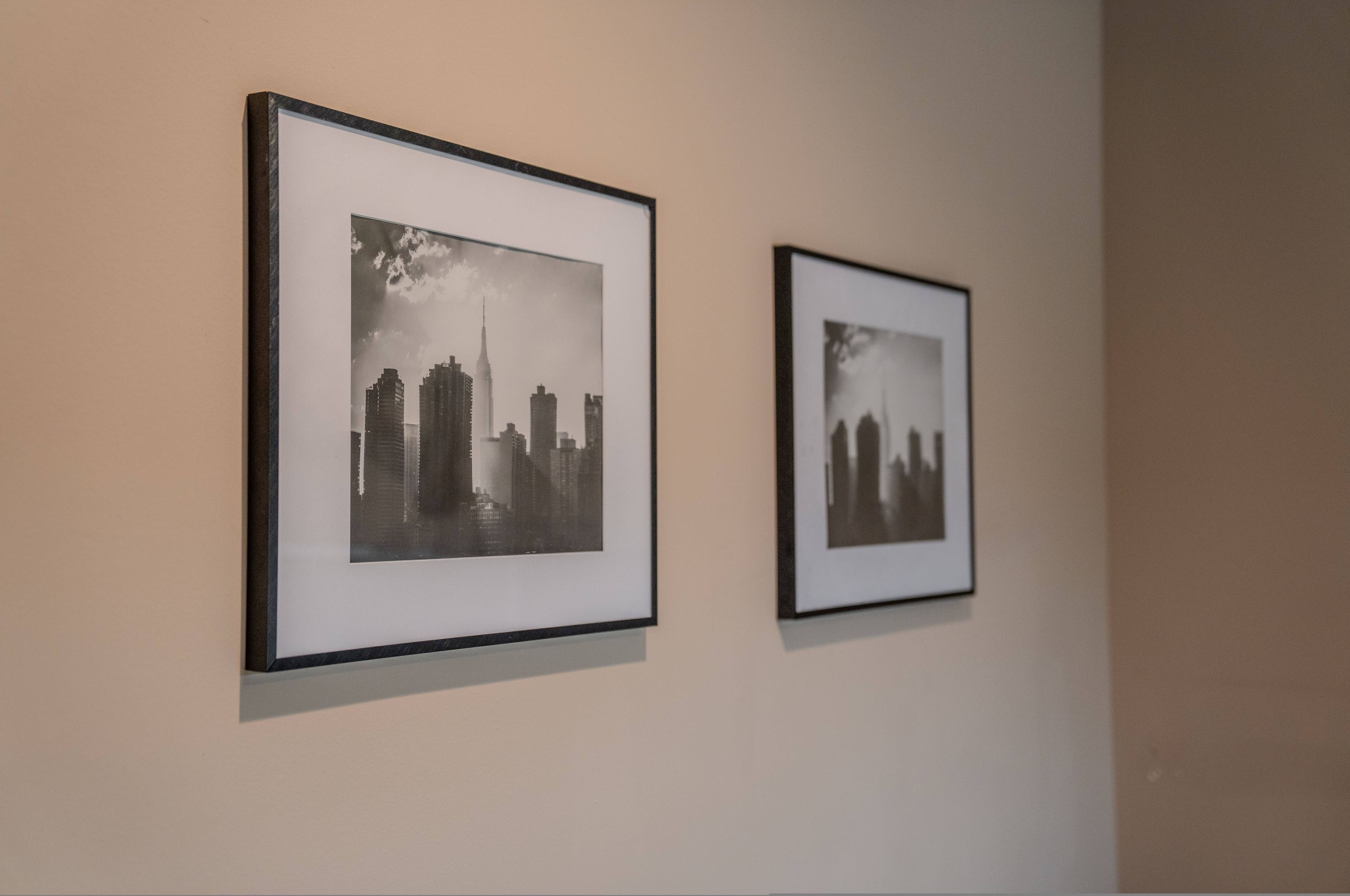 Zwei gerahmte Schwarz-Weiß-Fotos von Stadtansichten an einer Wand.