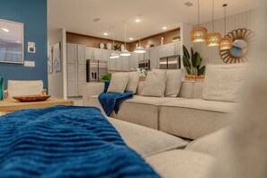 Ein modernes Wohnzimmer mit einer Couch, einem Couchtisch und einer blauen Decke.
