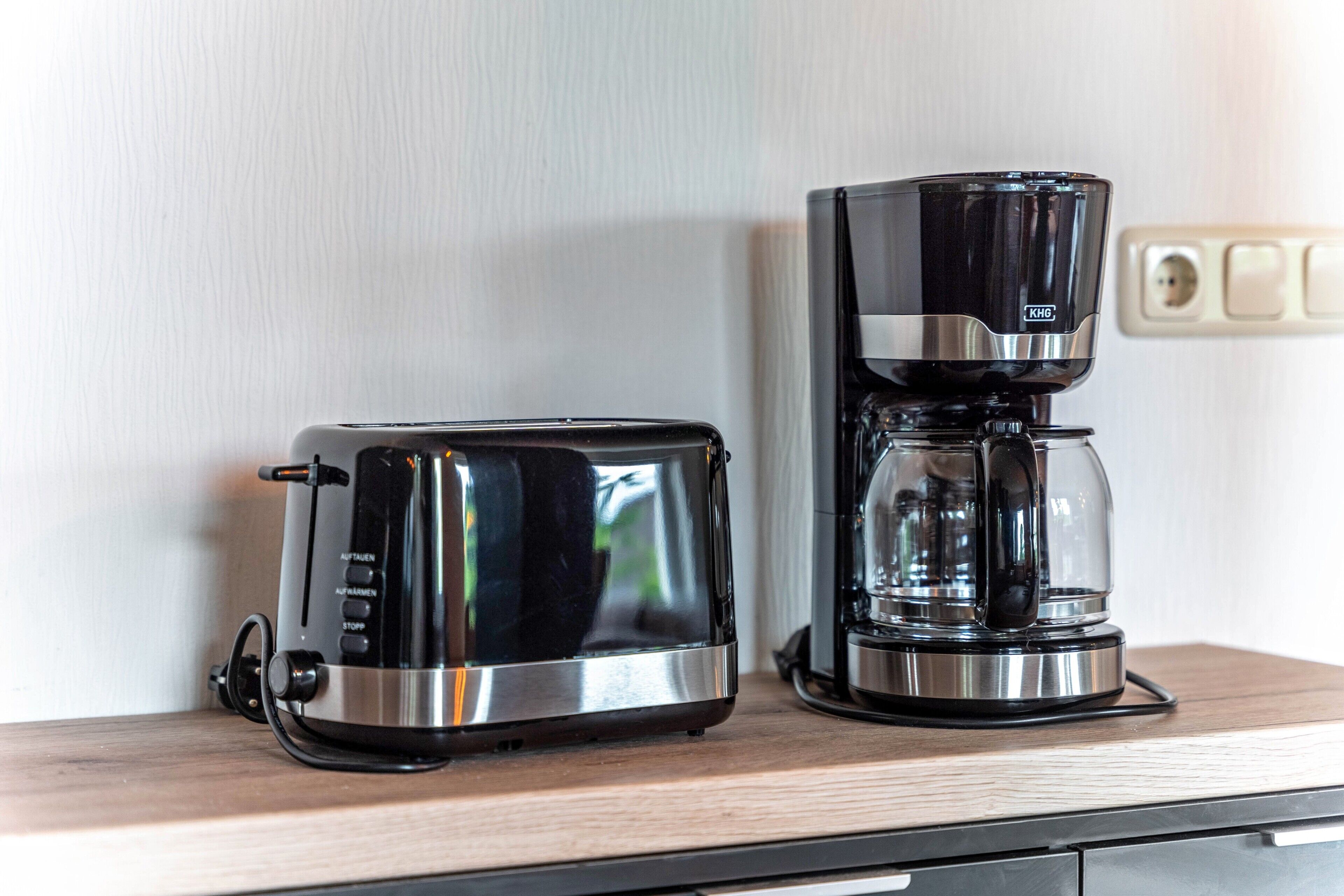Eine Küche mit Toaster und Kaffeemaschine auf einer Holzausziehtafel.