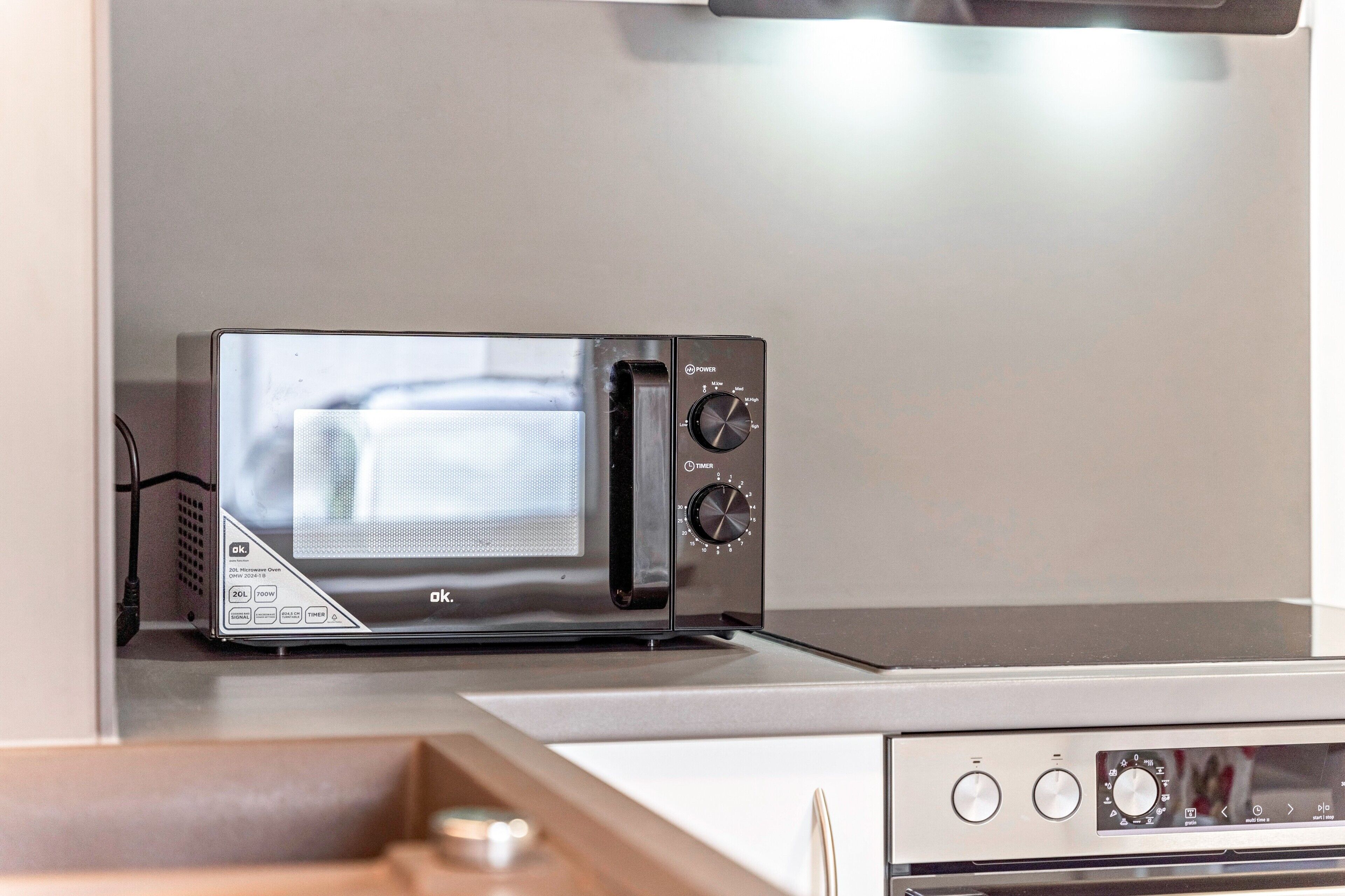 Une cuisine équipée d’un four à micro-ondes encastré, d’une cuisinière et d’un meuble à tiroirs.