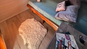 L’intérieur d’une cabine comprenant un lit superposé, une petite table et une fenêtre avec des rideaux.