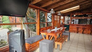 Ein Holzhütten-Interieur mit Fernseher, Holzmöbeln und großen Fenstern.