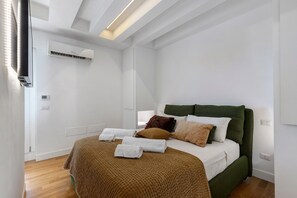 A bedroom with a bed, pillows, a blanket, an air conditioning unit, and a window. - Suite House Cassia: Vacation Home with Mountain View, Wi-Fi, and Air Conditioning (Roma)