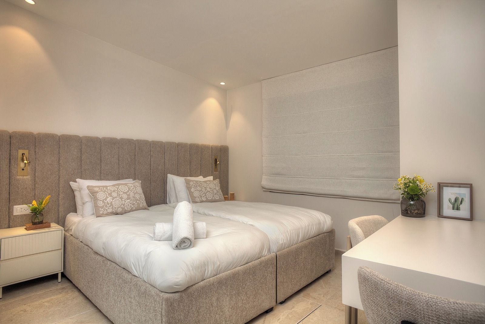 Une chambre à coucher moderne avec un grand lit, des tables de chevet, un bureau et une chaise.
