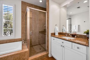 A modern bathroom with a walk-in shower, a bathtub, a sink with a granite countertop, and a large mirror. - Desert Haus #B | Studio Legacy Villas (La Quinta)