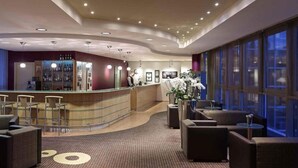 A hotel lobby with a reception desk, seating area, and large windows. - 1 Person Holiday Park Home in Dortmund (Dortmund)