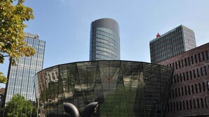 A modern glass building with a curved facade, surrounded by other high-rise buildings. - 1 Person Holiday Park Home in Dortmund (Dortmund)