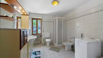 Ein Badezimmer mit Toilette, Bidet und Waschmaschine.