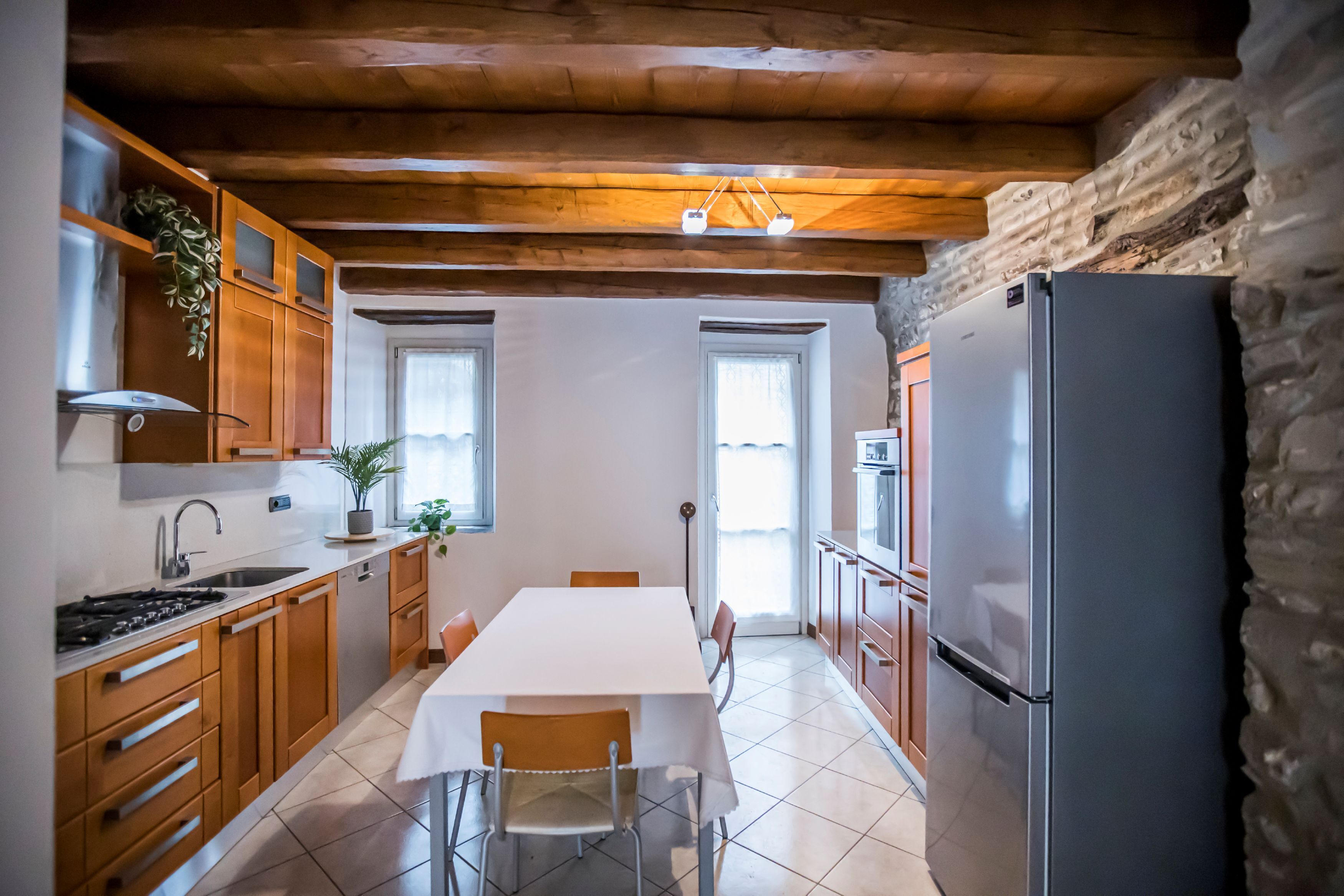 A kitchen with wooden cabinets, a white table, and a refrigerator.