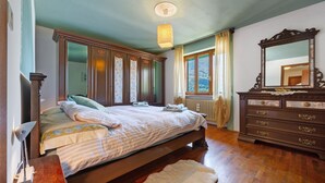 Une chambre à coucher avec un lit, une commode et un grand miroir.