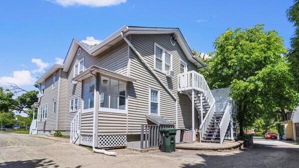 A two-story house with a porch, a staircase, and a driveway.