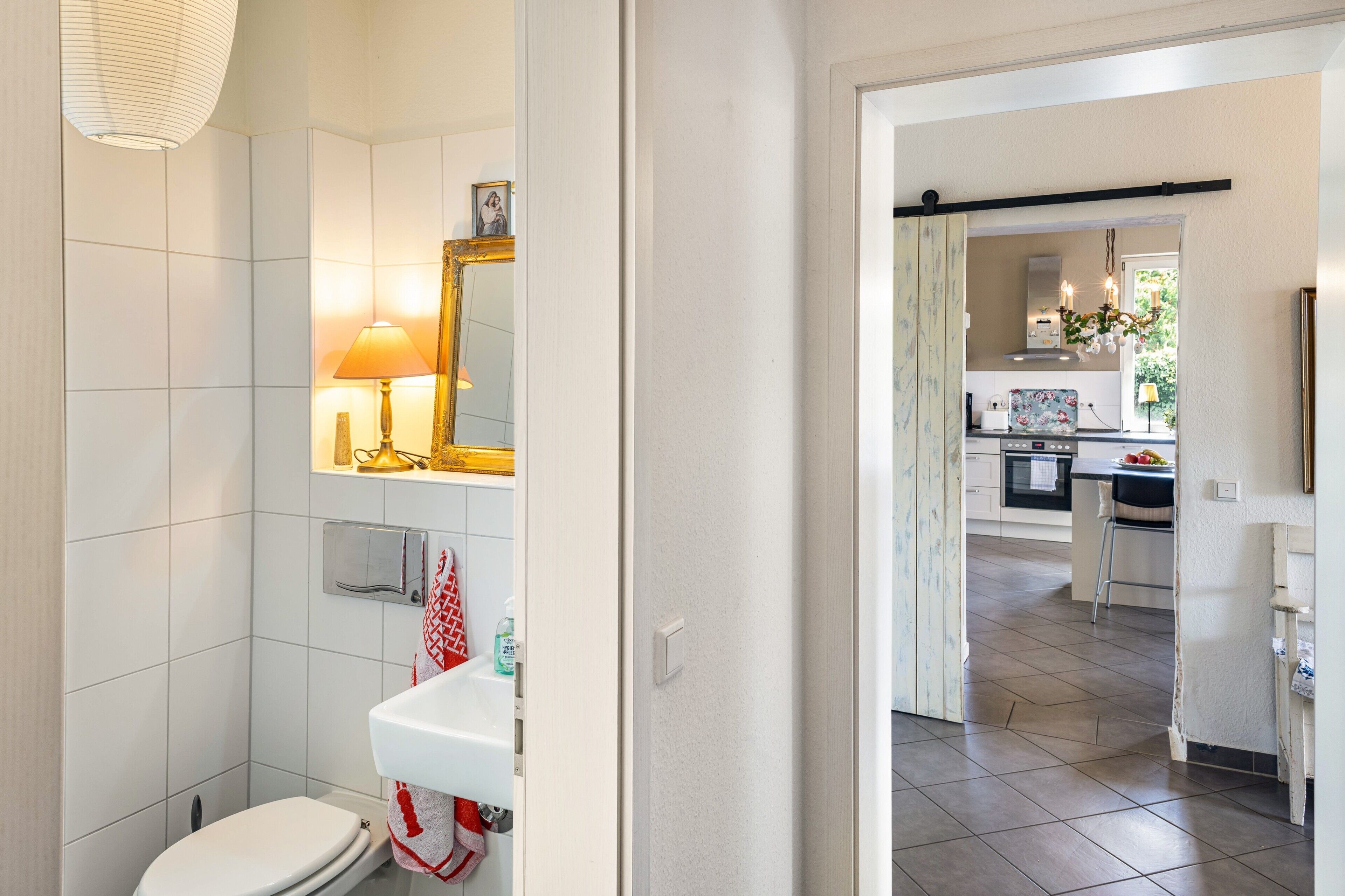 Ein Badezimmer mit Toilette, Waschbecken, Spiegel und Handtuchhalter.