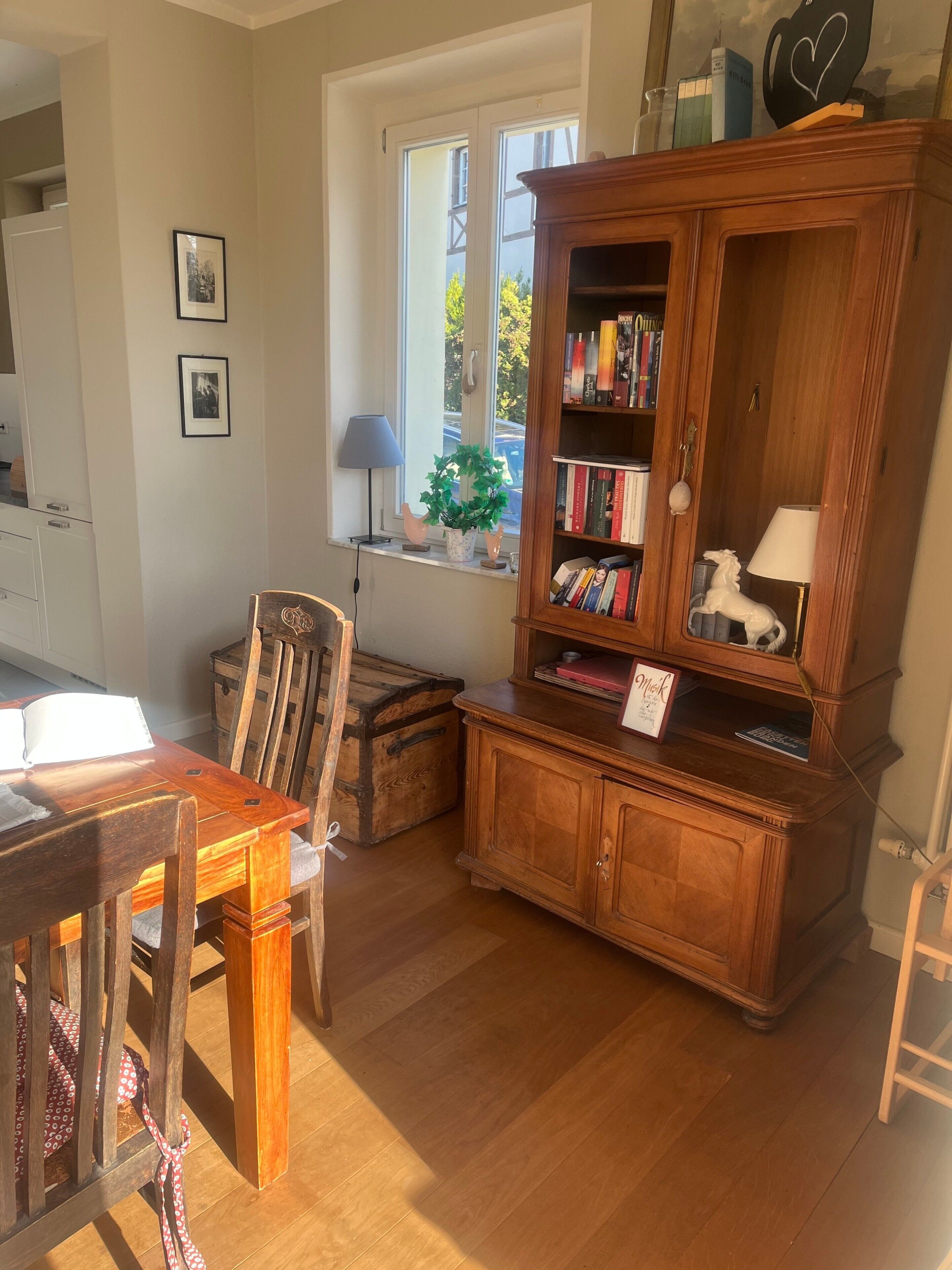 A wooden bookcase with books, a lamp, and a small potted plant.