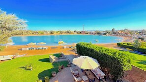A resort with a large pool, sun loungers, and a view of the surrounding landscape.
