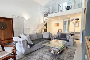 Ein modernes Wohnzimmer mit einer Couch, einem Couchtisch und einer Treppe, die in eine obere Etage führt.