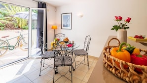A dining area with a table, chairs, a lamp, and a basket of vegetables. - French Riviera Bay Retreat (Arcachon)