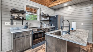 A kitchen with a built-in oven, a sink with a modern faucet, and a window above the counter.