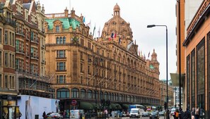 A historic building with ornate architecture, a large dome, and multiple flags. - Charming Studio Apartment near 3 Museums (London)