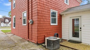 A red house with a white door and a small attached garage. - Walk to Downtown Sturgeon Bay! Large Home + Yard (Sturgeon Bay)