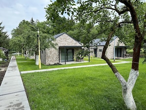A modern building with a brick facade, large windows, and a covered outdoor seating area.