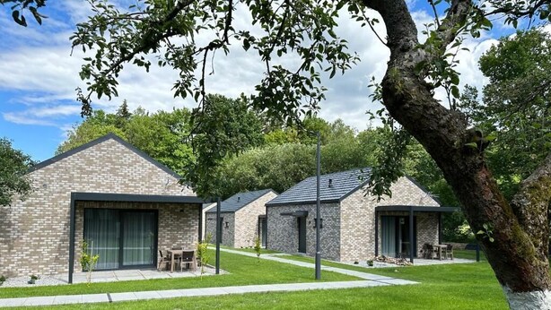 A row of modern brick buildings with large windows and a well-maintained lawn. - Domki Zdrojowe  (Polanica-Zdrój)