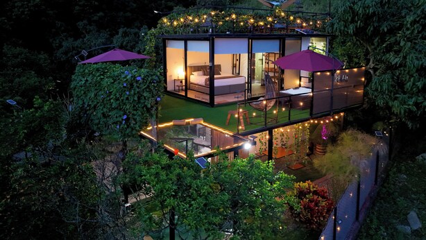 A modern house with a glass exterior, a balcony, and a garden area. - Oasis Glamping Tena Cundinamarca (Tena)