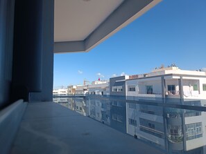 A balcony with a clear view of adjacent buildings, a crane, and a flag. - Quiet, central apartment ideal for families (Fès)