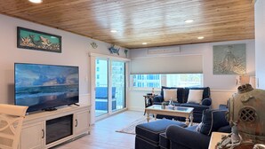 Ein Wohnzimmer mit Fernseher, einer Couch, einem Couchtisch und einer dekorativen Skulptur.