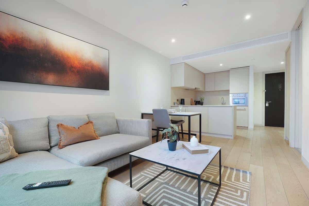 A modern living room with a sofa, a coffee table, and a painting on the wall.