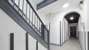 Ein modernes Interieur mit Treppe, Flur und einer Tür am Ende.