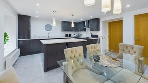 A modern kitchen with dark cabinets, a central island, and pendant lighting. - Charming 3-Bedroom Home in the Heart of Stanhope (Stanhope)