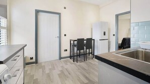 Una cocina moderna con comedor, refrigerador y lavamanos.